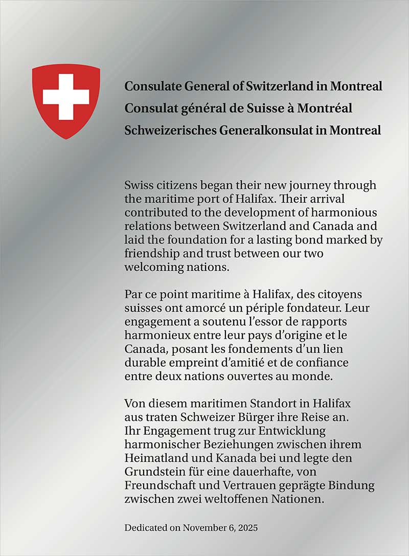 Shiny silver plaque with a crest and text.