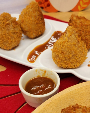 A white platter holding teardrop-shaped Coxinhas.