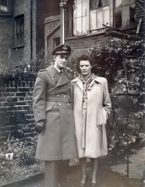 Black and white photo, Les and Joan are standing side by side in their back garden in London.