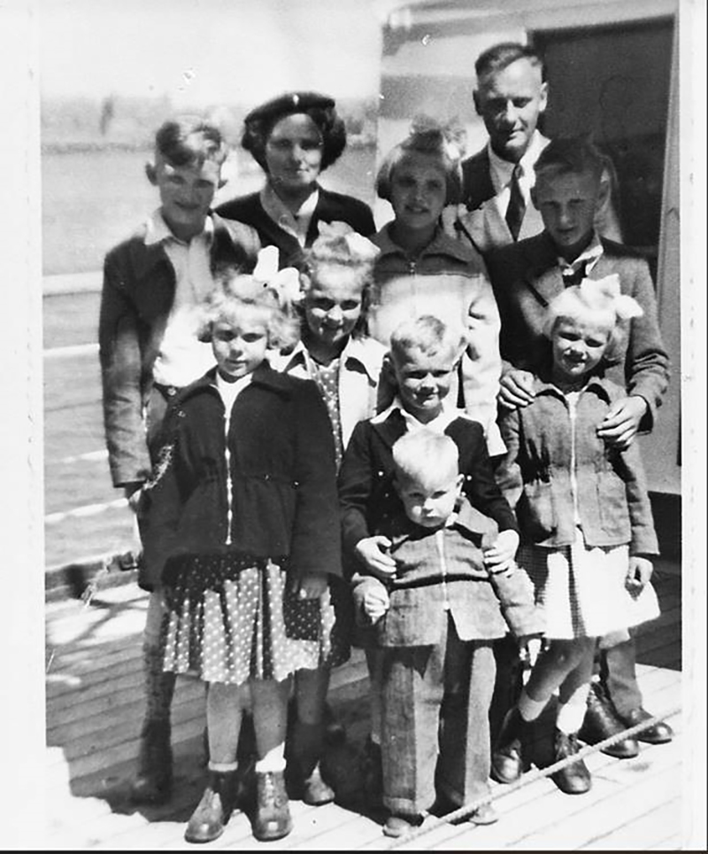 Old black and white photo of a family of ten.
