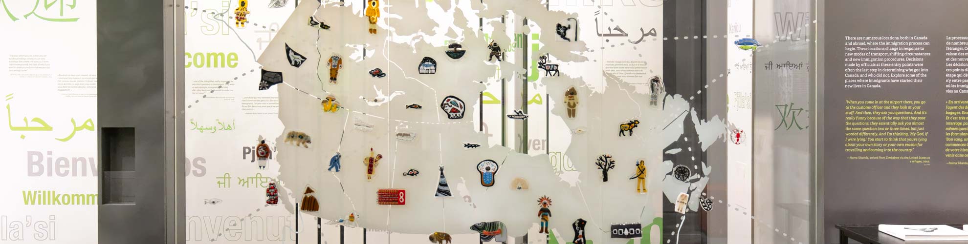 A large map of Turtle Island on a glass wall with Indigenous glass art throughout.