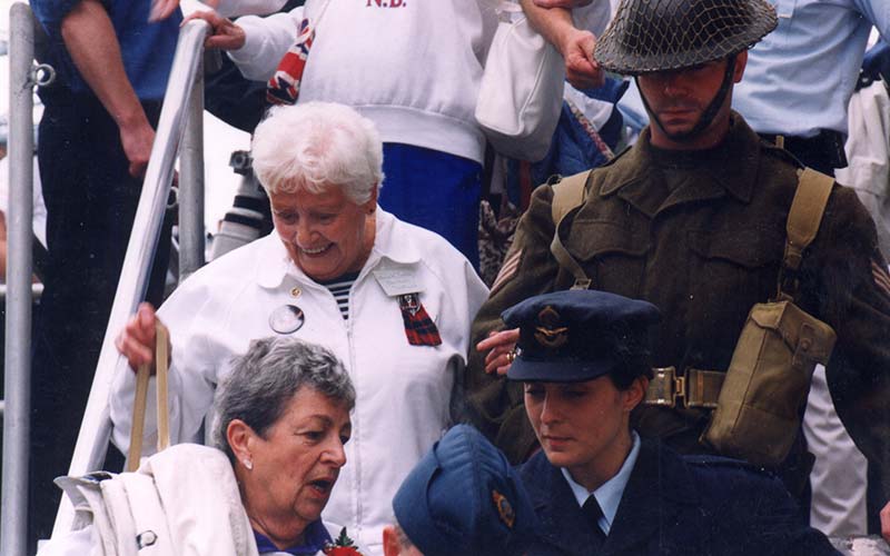 Men and women descending the steps on to shore.