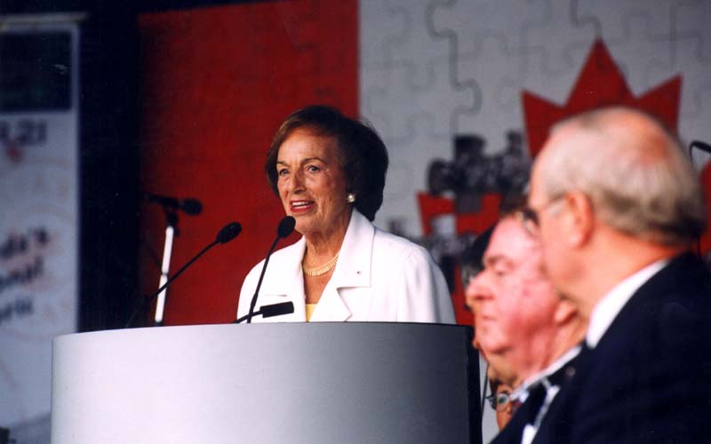 A smiling woman is behind the podium.