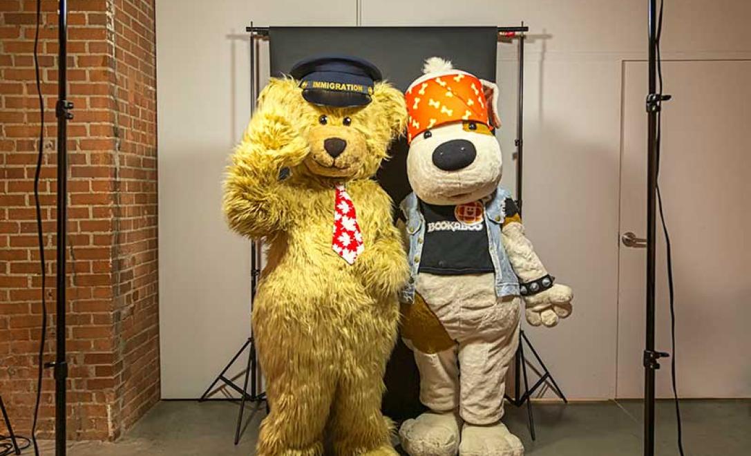 Two adults dressed in bear and dog mascot costumes.