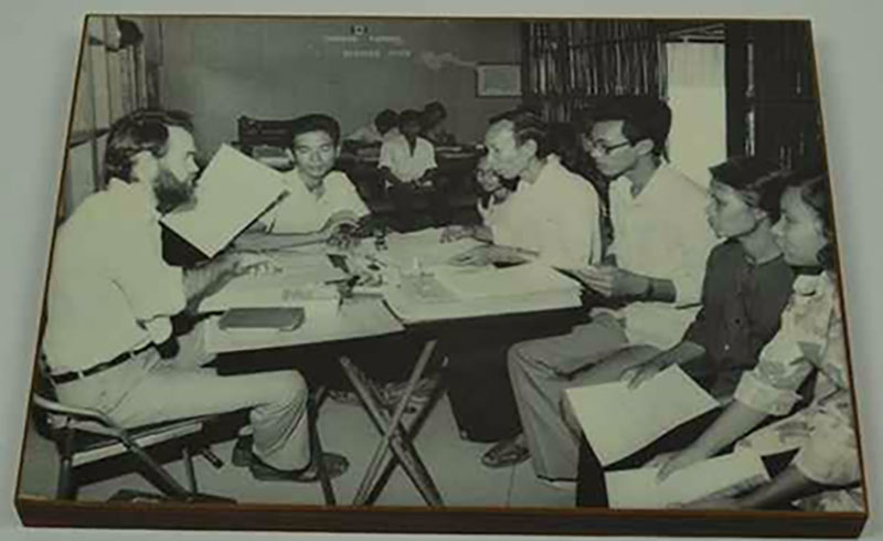 A group of people sitting in front of the immigration officer.