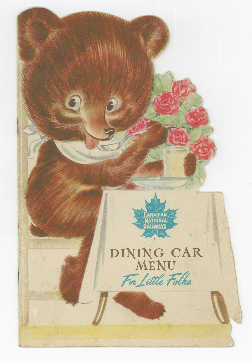 Front cover of an old-fashioned train’s menu, showing a cartoon bear with a bib seated at a table.