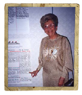 A woman poses with posters of text on the wall.