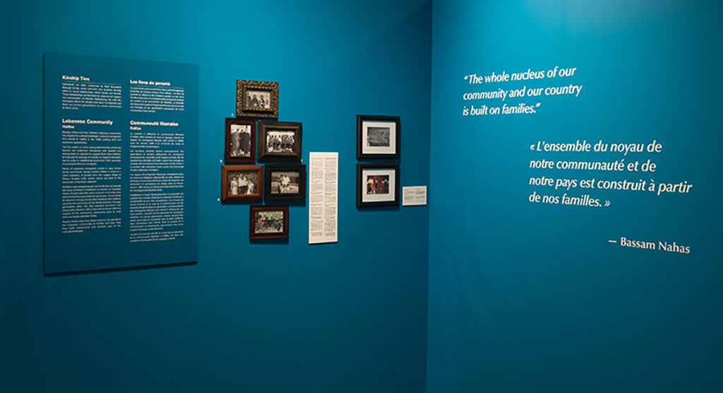 Two sections of a teal-coloured wall, with frames of varying size showing text and images.