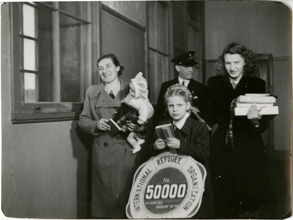 A young woman is awarded with gifts as she stands next to her mother.