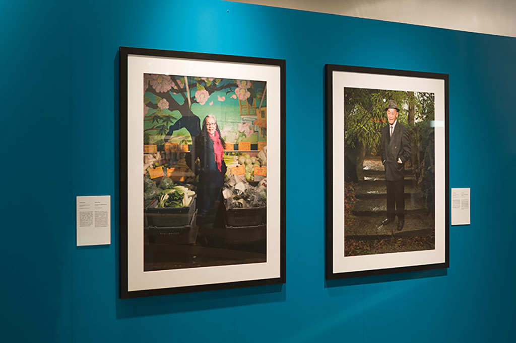 Two beautiful portraits hang on a teal-coloured wall.