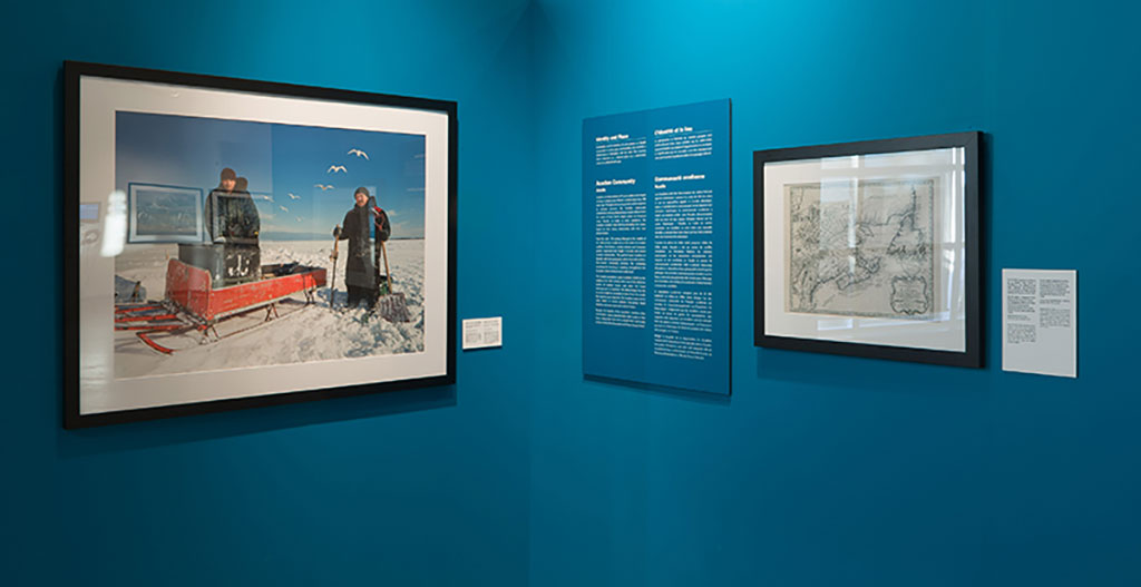 A large portrait of two men standing in the snow hangs on a teal-coloured wall.