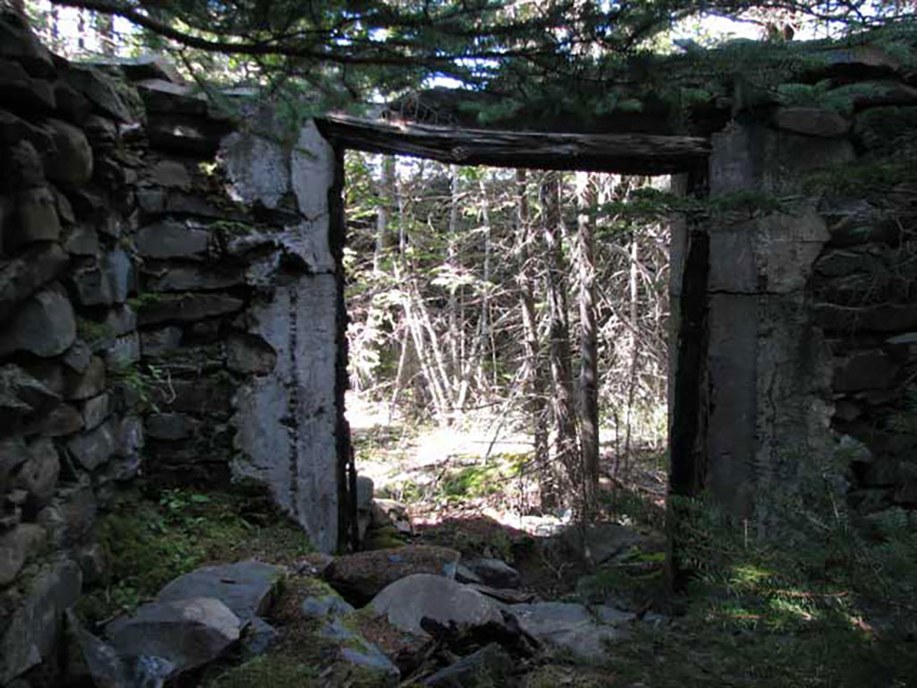 View of doorway of old abandoned stone building.