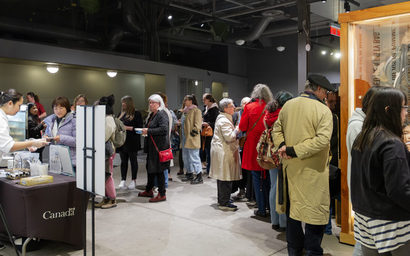 A crowd of people waits in lines for food.