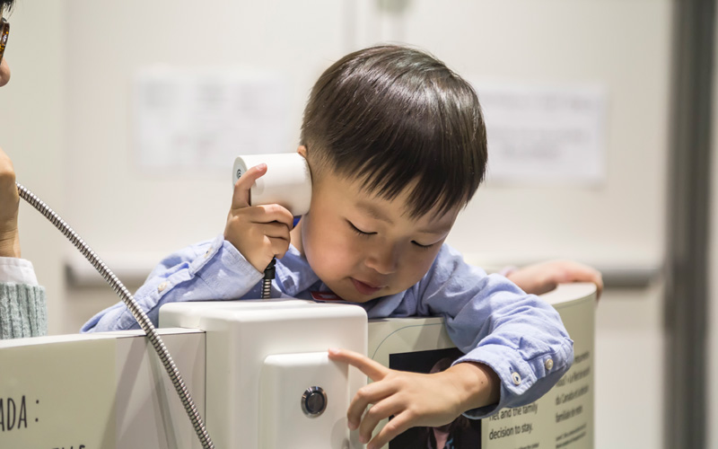 A child uses an audio device to listen to part of the exhibit.