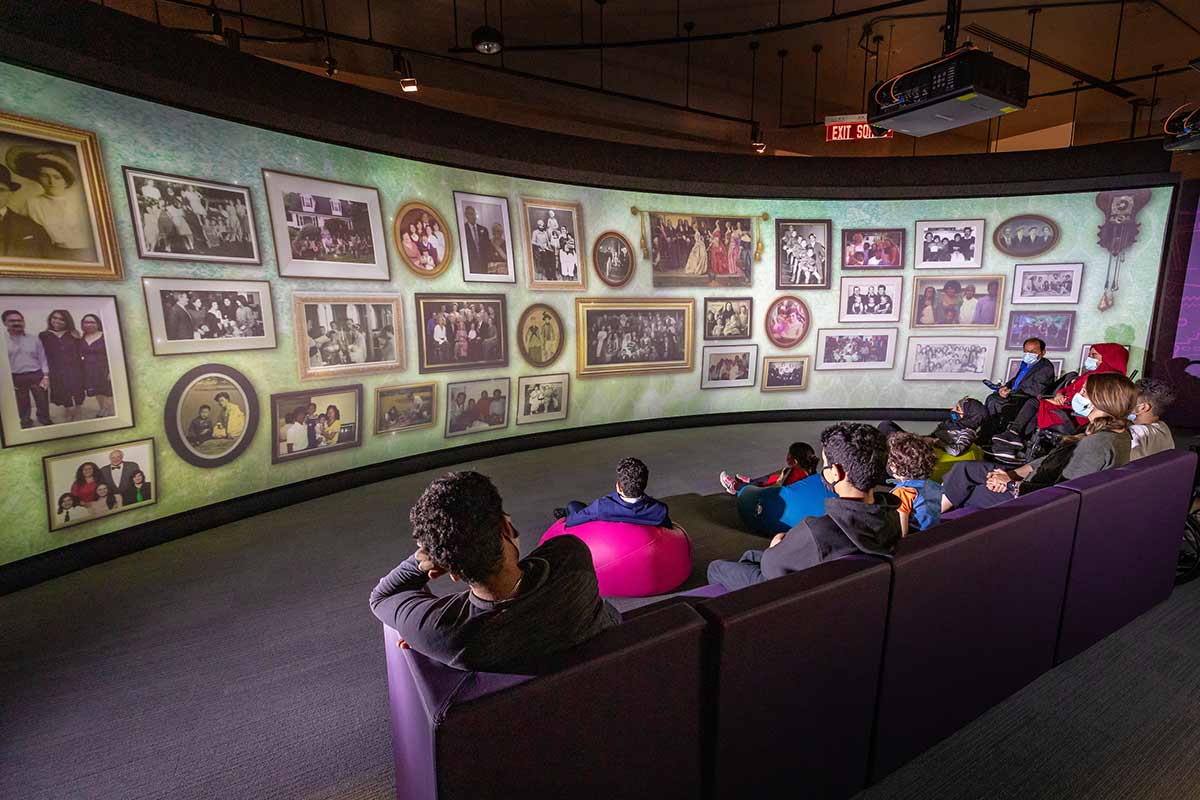 A school group intently watches the film from a long couch.