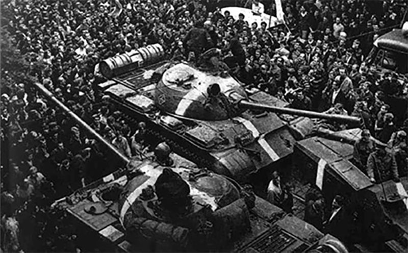 Historical photo of tanks surrounded by crowds of people.