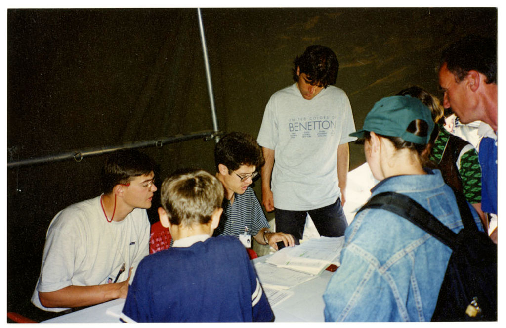 A group of people are looking at paper documents on a table.