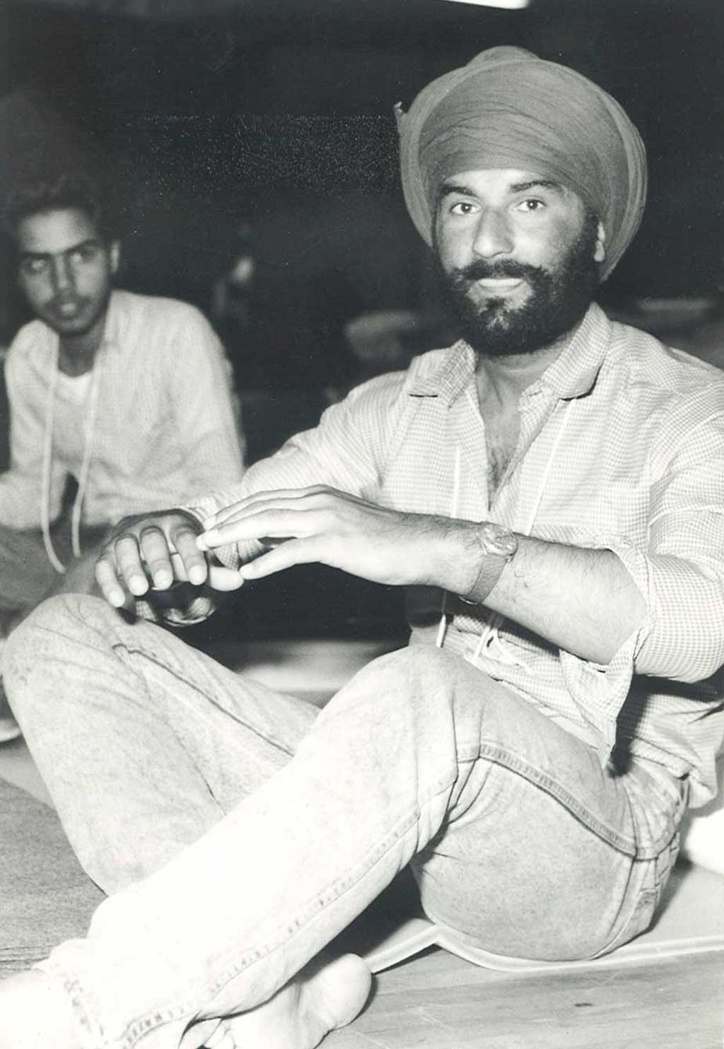 Two men sit on the floor with their legs crossed.
