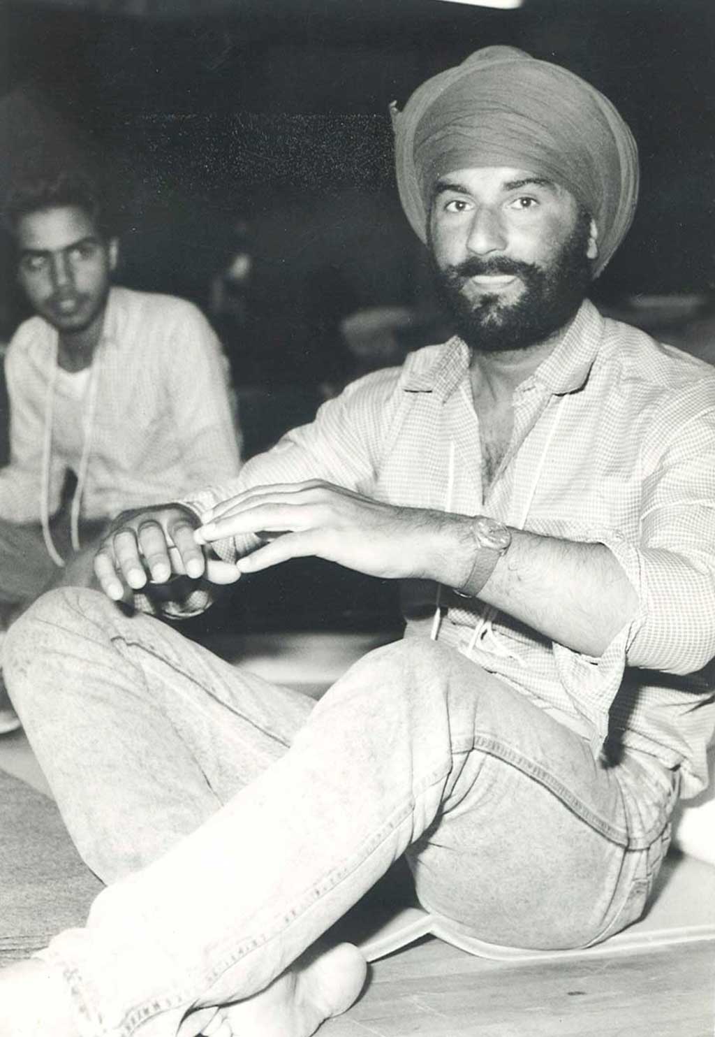 Two men sit on the floor with their legs crossed.