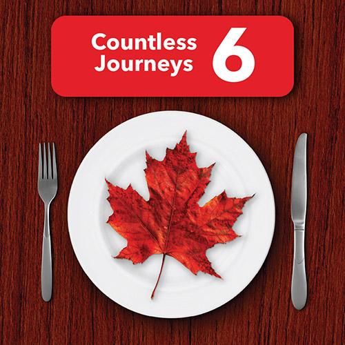 A dinner plate on a wooden surface with a maple leaf on it, and a red banner that says Countless Journeys Six.