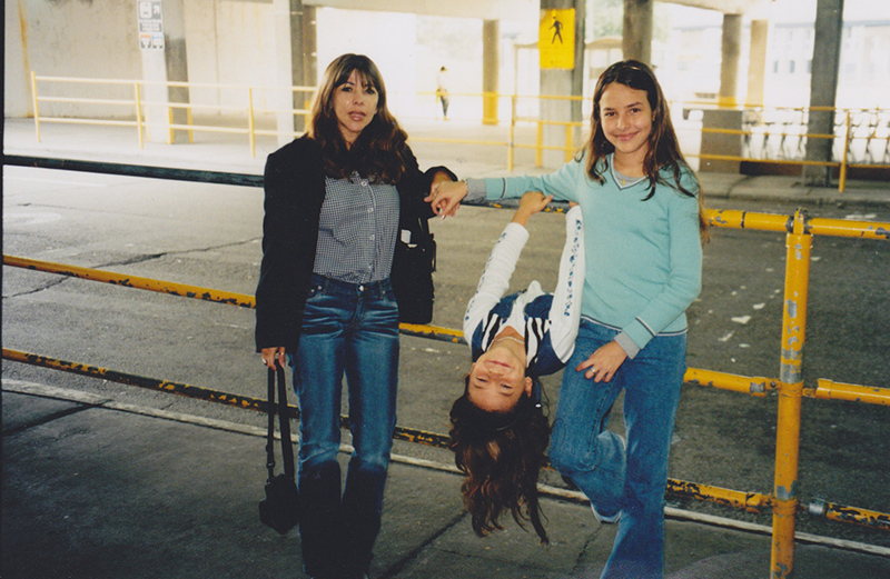 Photograph of Monica Valencia with her mother and sister at the Detroit Metropolitan Airport, 2002.