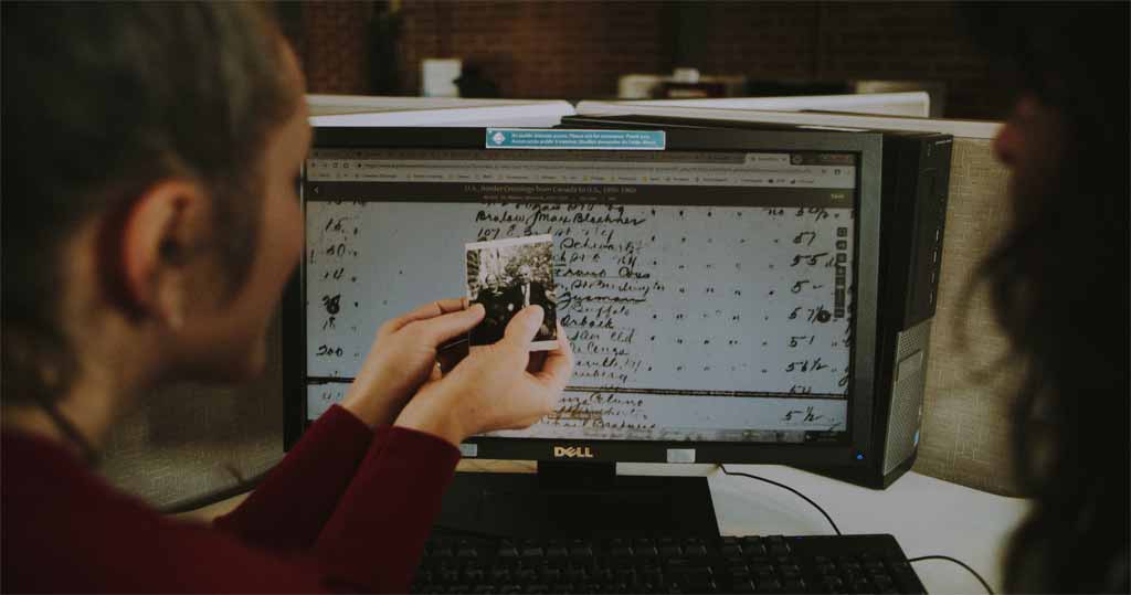 Person holding a wedding photo and looking at historical records