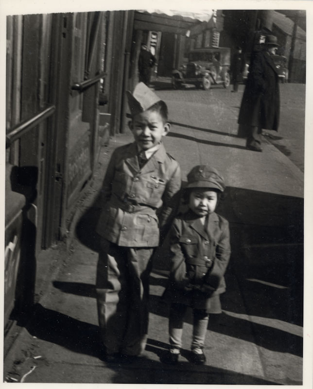 Two young children in military style clothes. Black and White photo.