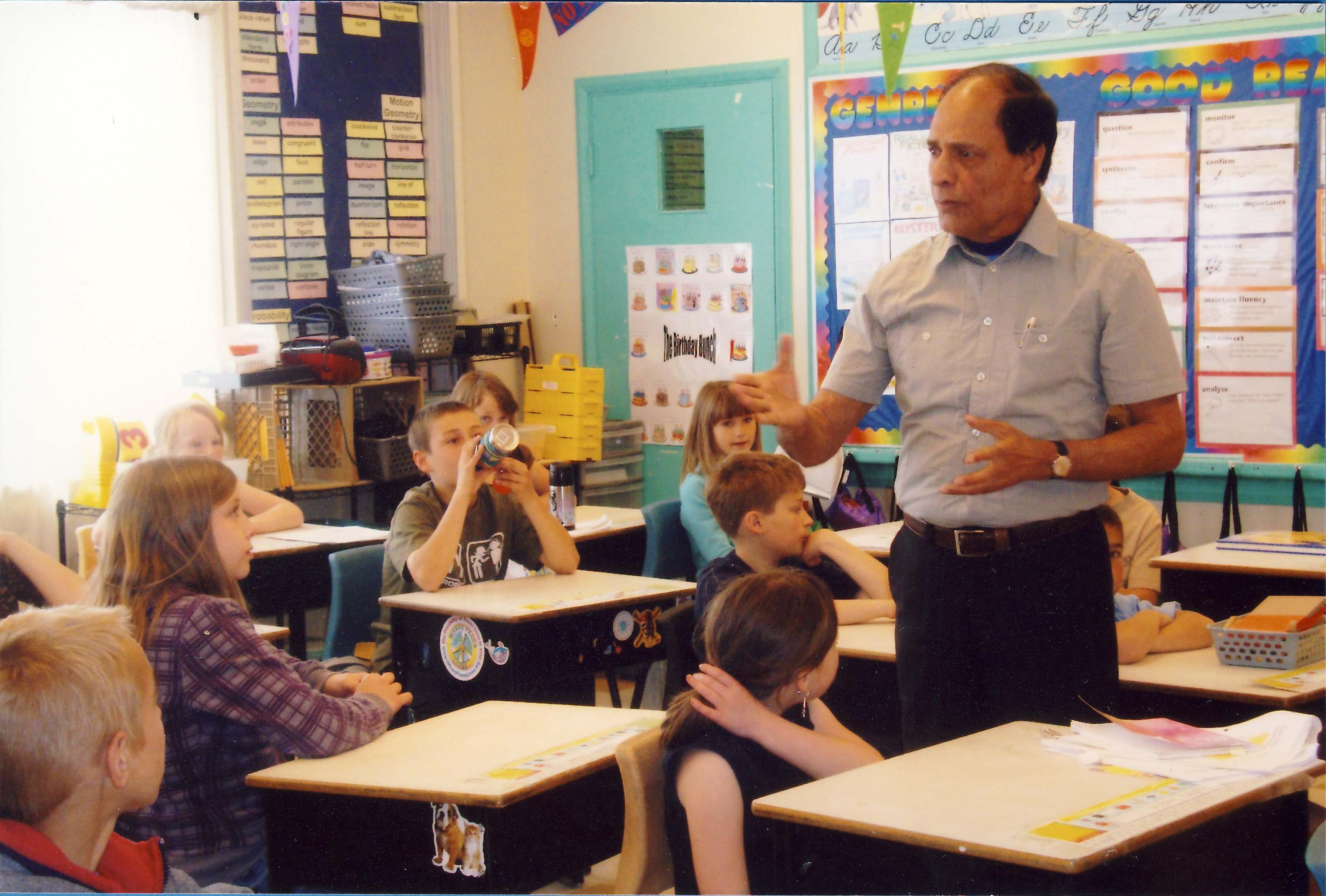 A man teaches class of young students.