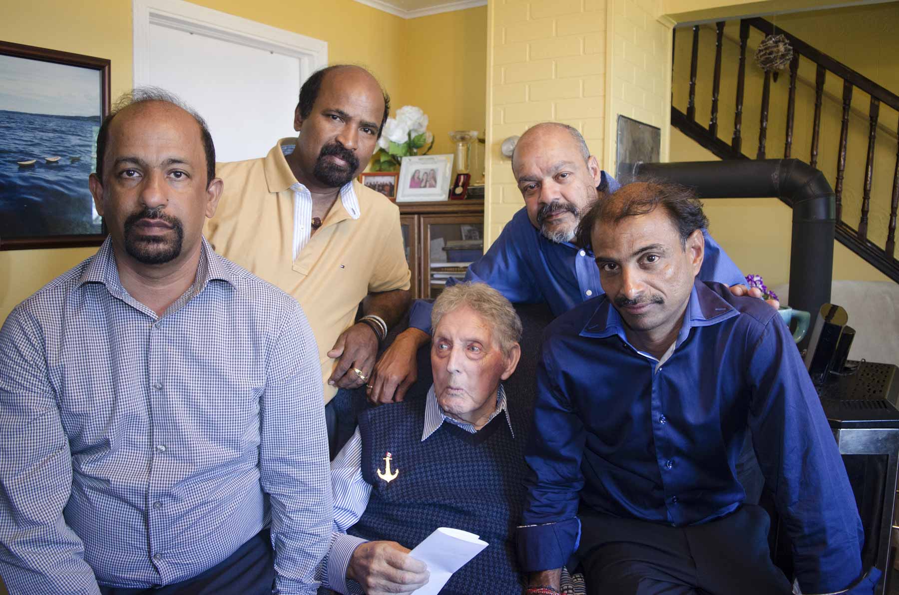 Four middle aged Tamil men pose with an elderly white man.