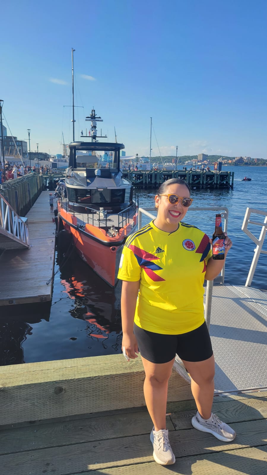 Nathaline, in a Colombian soccer jersey, poses on a boardwalk.