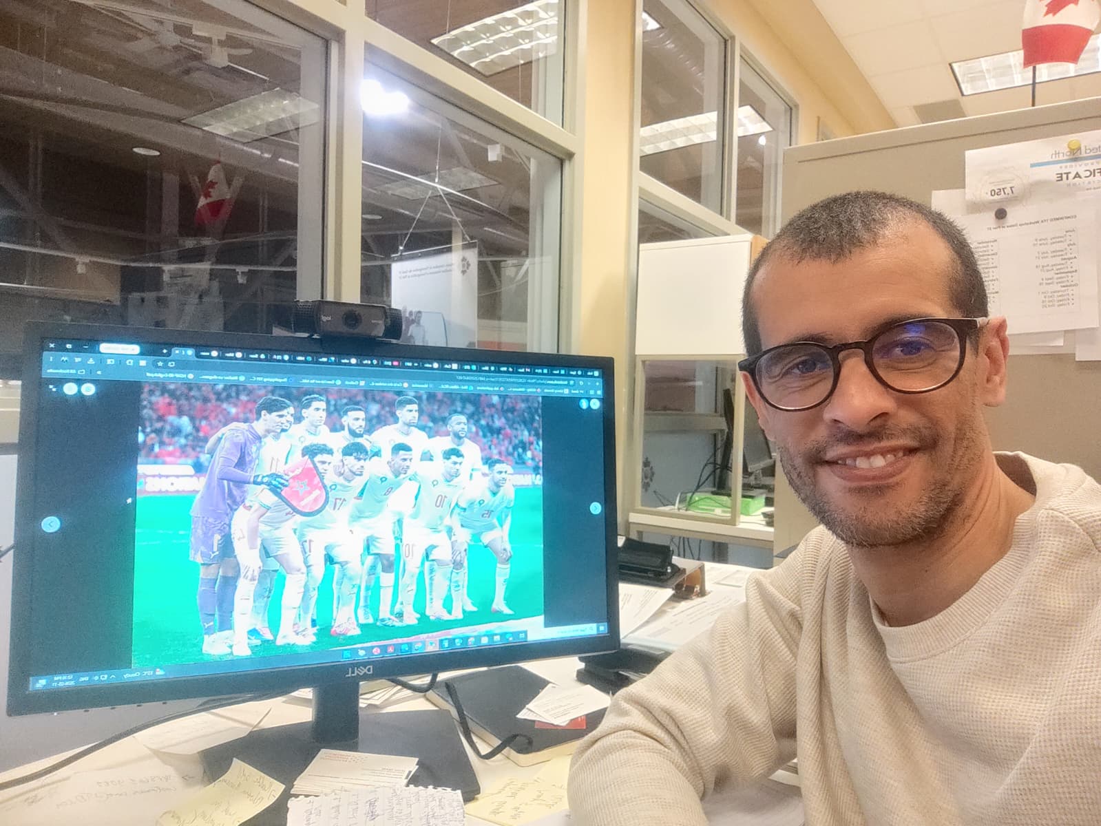 Saïd, at his desk, with a picture of the Moroccan national soccer team on his screen.