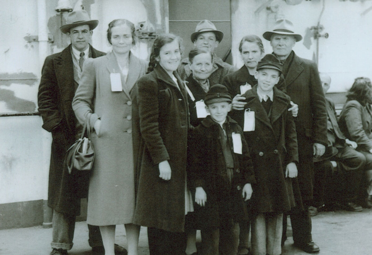 A family of nine poses aboard a ship.