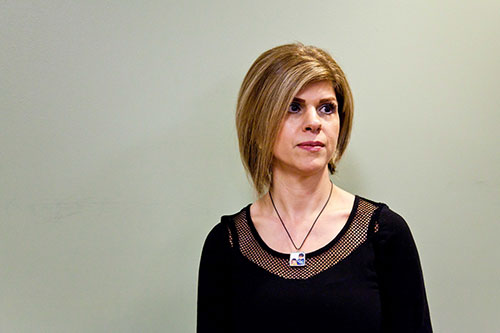 Portrait of a woman wearing a black blouse and a small picture of two boys hangs from her necklace
