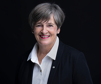 A portrait of Sherry Porter smiling at the camera against a black backdrop.