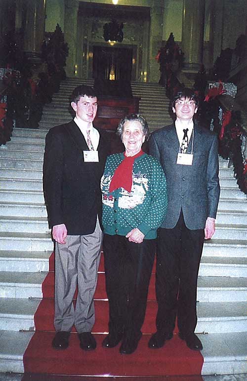 Beautiful woman with two young boys standing side by side on the stairs.