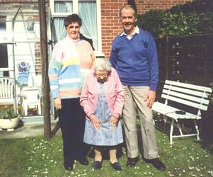 Audrey as an older woman, pictured with brother and elderly mother in back garden.