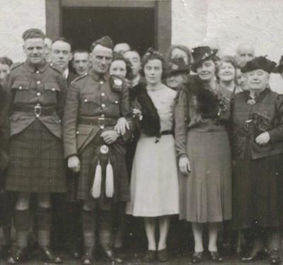 Group photo on a wedding day, with men in traditional kilts.