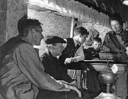 Candid shot of several family members seated in kitchen.