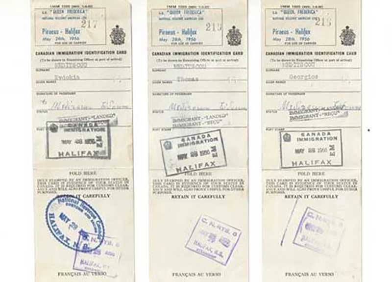 Three Canadian Immigration Identity Cards with stamps on them.
