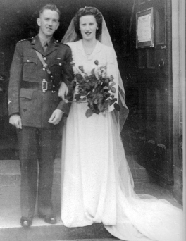 Dwyer bride and groom on their wedding day, standing in doorway.