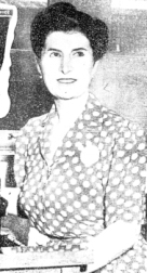 Woman seated, wearing polka-dot dress.