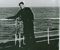 Young Cornelius leaning against railing aboard ship.