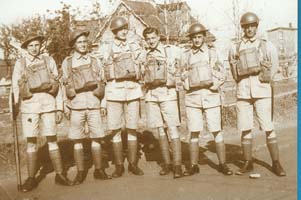 Old photo showing six young men standing in army uniforms.