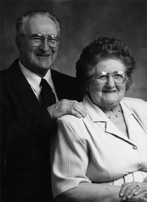 A man and woman pose for a portrait-style photo.
