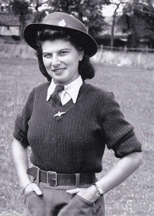 A young lady is wearing hat and has her hands in her pockets.