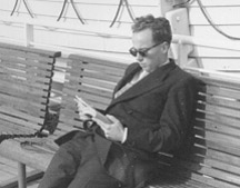 Man seated on deck chair of ship.
