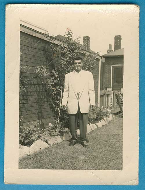 Archival image of a young man standing in a garden.