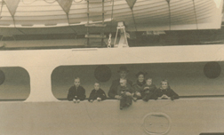 Mother, father and children on deck of ship.