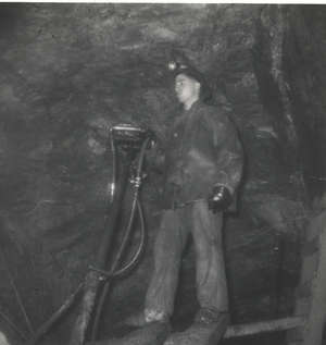Young man working with equipment in an underground mine.
