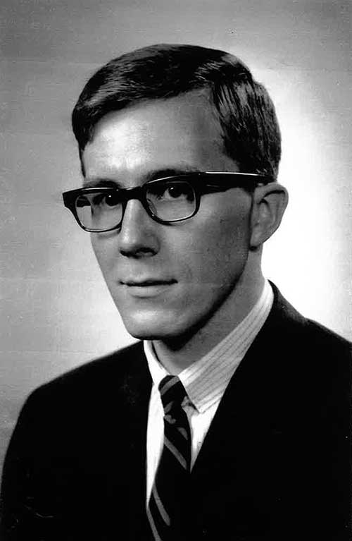 A portrait of a young man wearing glasses.